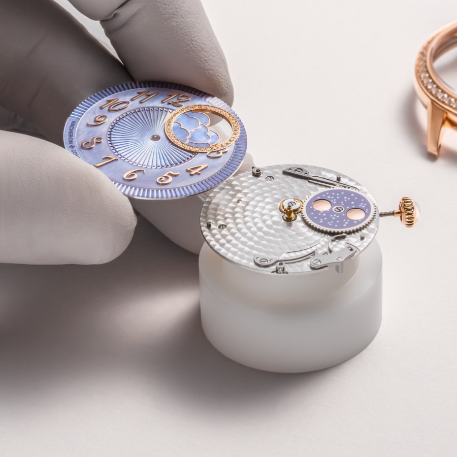 Watchmaker assembling components in the caliber of an Égérie Moon phase with a purple dial