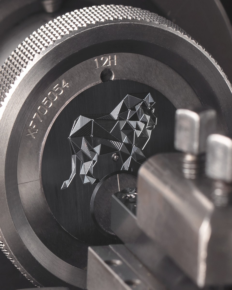 Guilloche machine engraving a stylized lion motif on a metal plate.