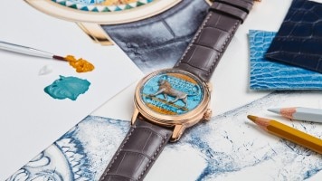 A watch with a brown leather strap, a blue watch case engraved with a lion, and a gold frame .