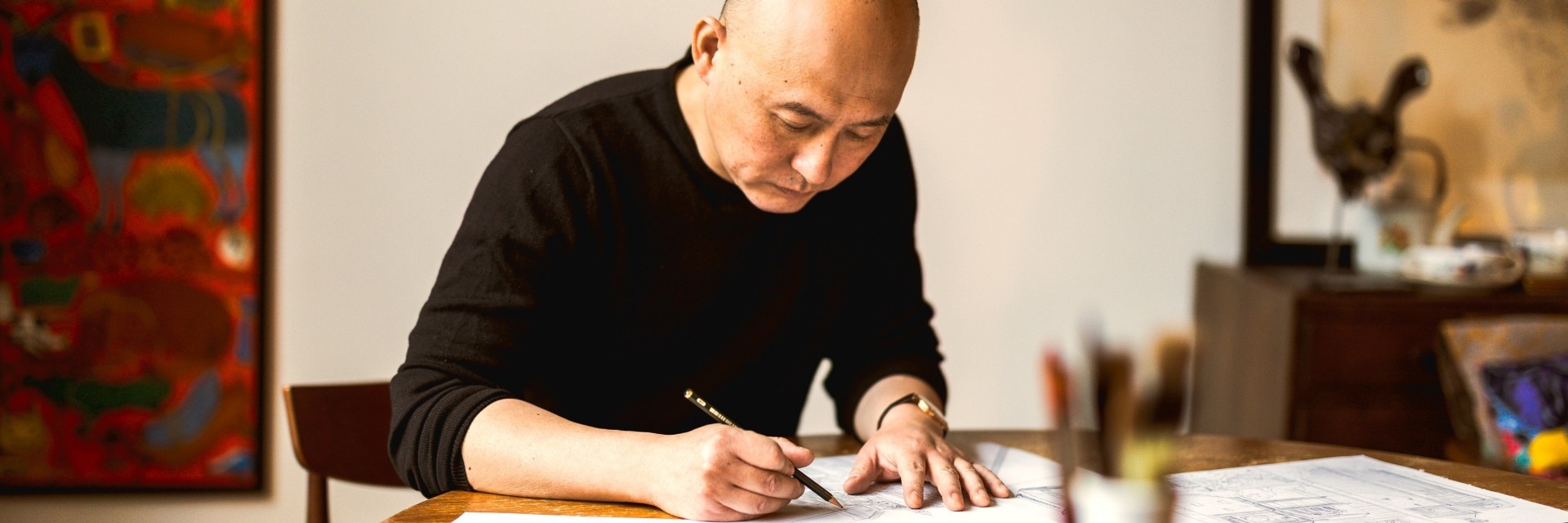  插畫家江杉於桌前作畫