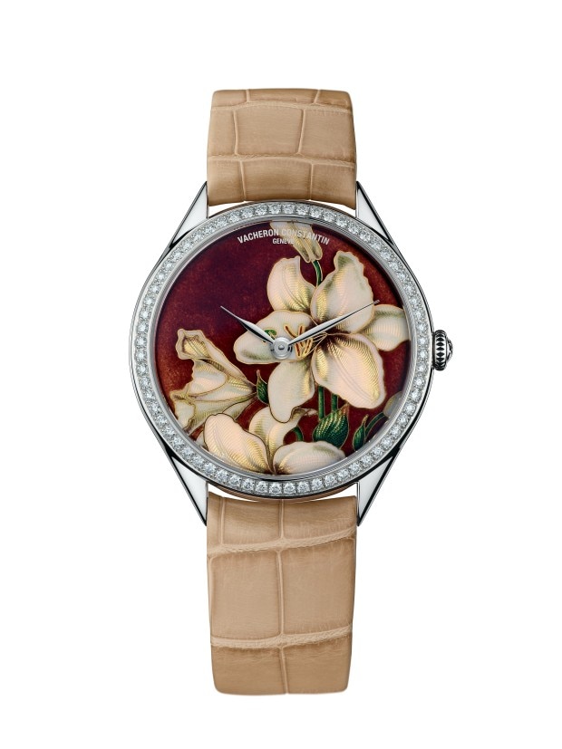 Elegant wirstwatch with a floral enamel dial, diamond bezel, and a beige leather strap.
