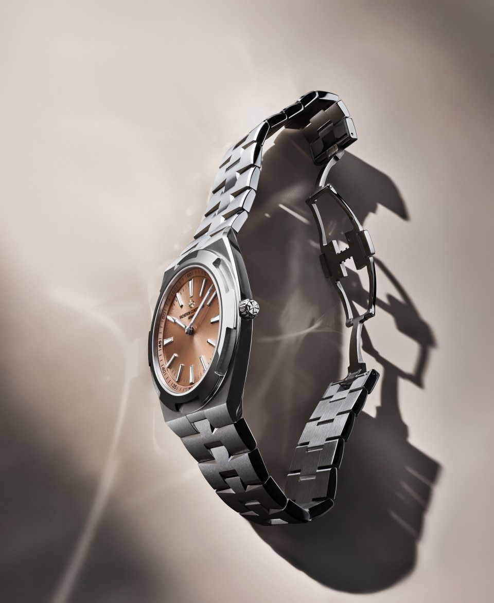 Side view of a stainless steel wristwatch with integrated bracelet and brown dial.