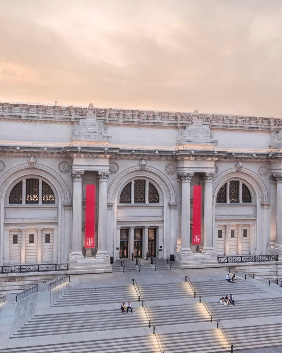 Front entrance of The Met with red banners and classical architecture.