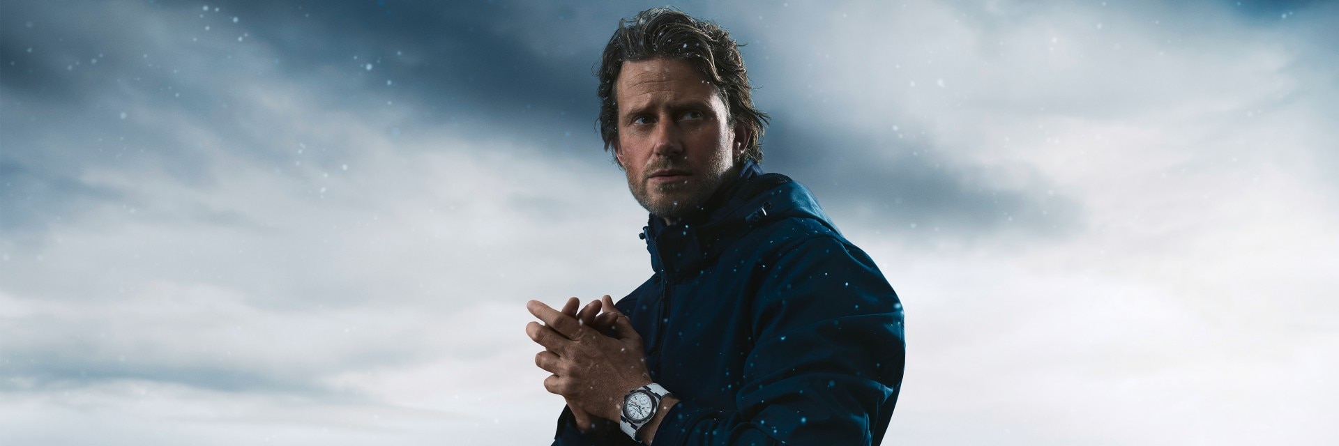 Кори Ричардс в белых часах Overseas Dual Time Cardinal Points на заснеженном фоне.