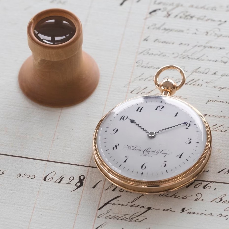 Close-up view of a round watch case with a gold frame and black numbers on a white bezel