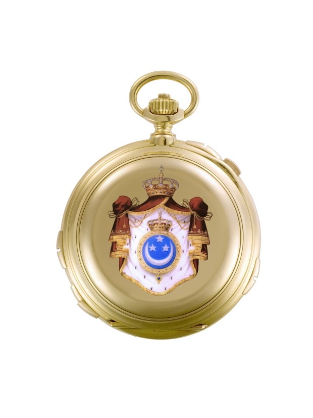 Gold pocket watch with an orinate royal crest on the cover.