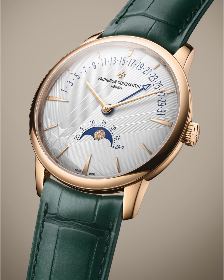 Patrimony - Moondphase und retrograde Datumsanzeige Eine luxuriöse Armbanduhr mit grünem Lederarmband, goldenem Gehäuse, Tag- und Monatsmarkierungen und Mondphasenanzeige.