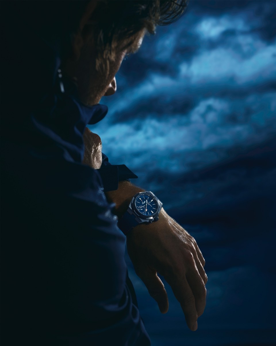 Кори Ричардс с синими часами Overseas Dual Time Cardinal Points на фоне облачного неба