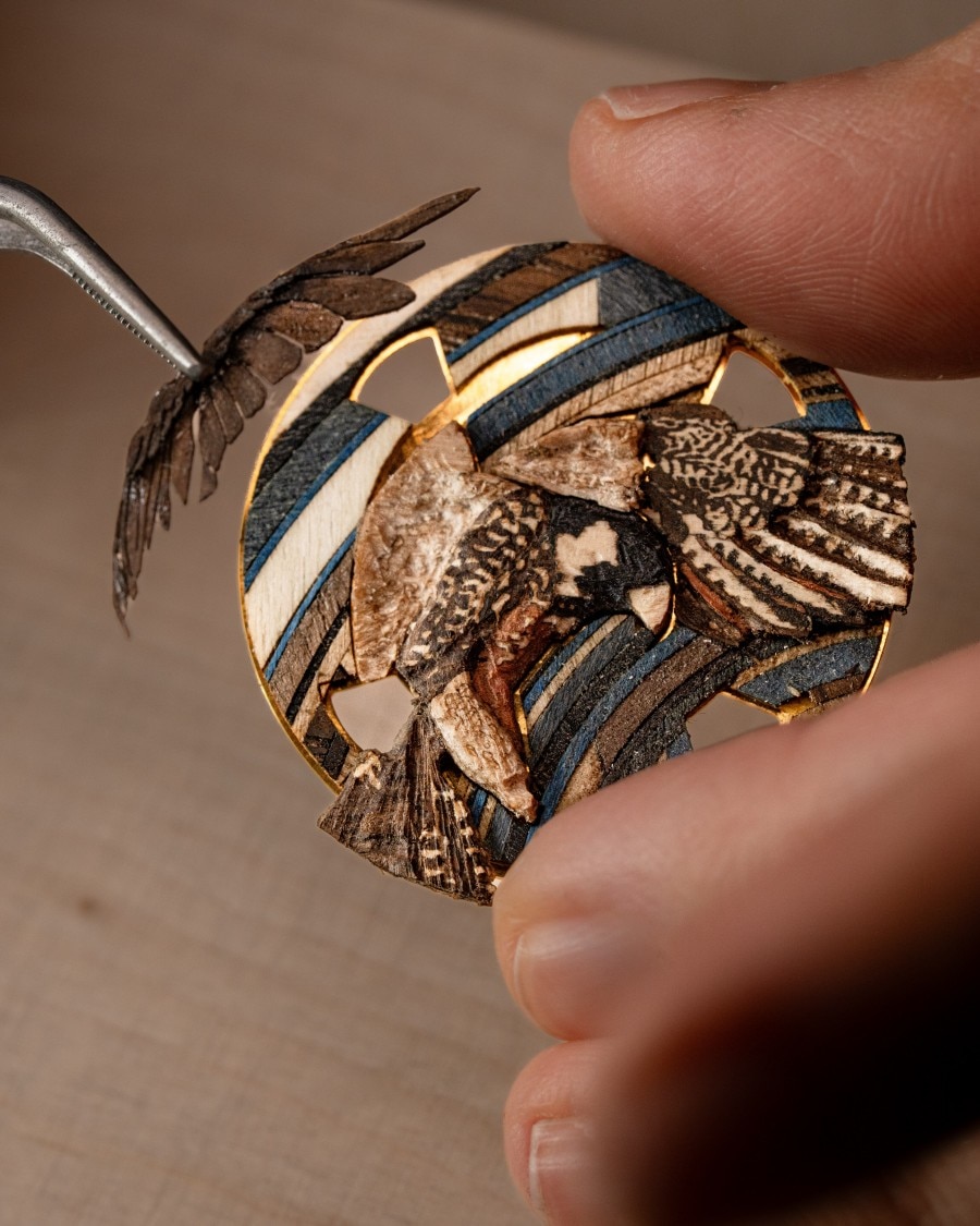 Close-up of a handmade bird wood inlay with fine natural wood details.