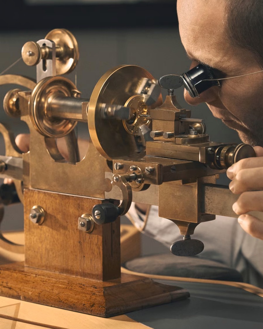 Un orologiaio crea un orologio da polso di lusso con una macchina speciale.