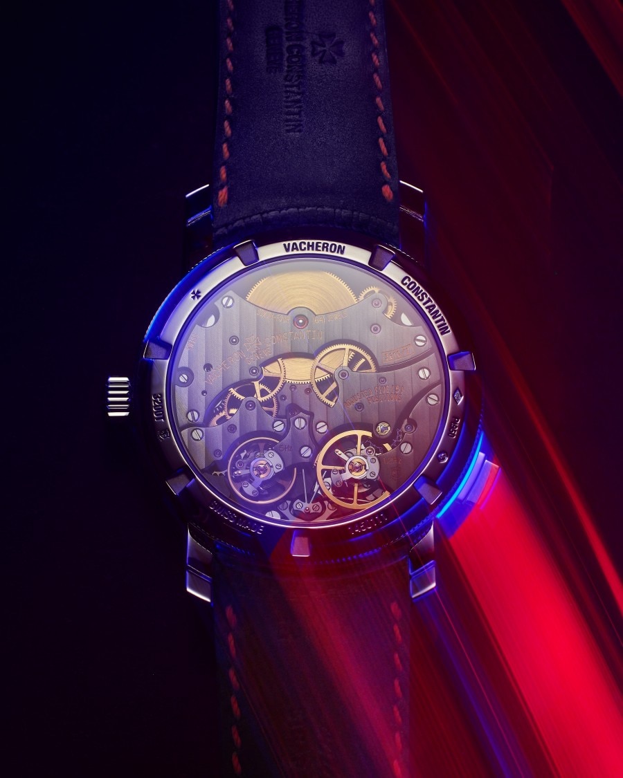 Caseback view of the Traditionnelle Twin Beat Perpetual Calendar with neon lighting on a dark background.