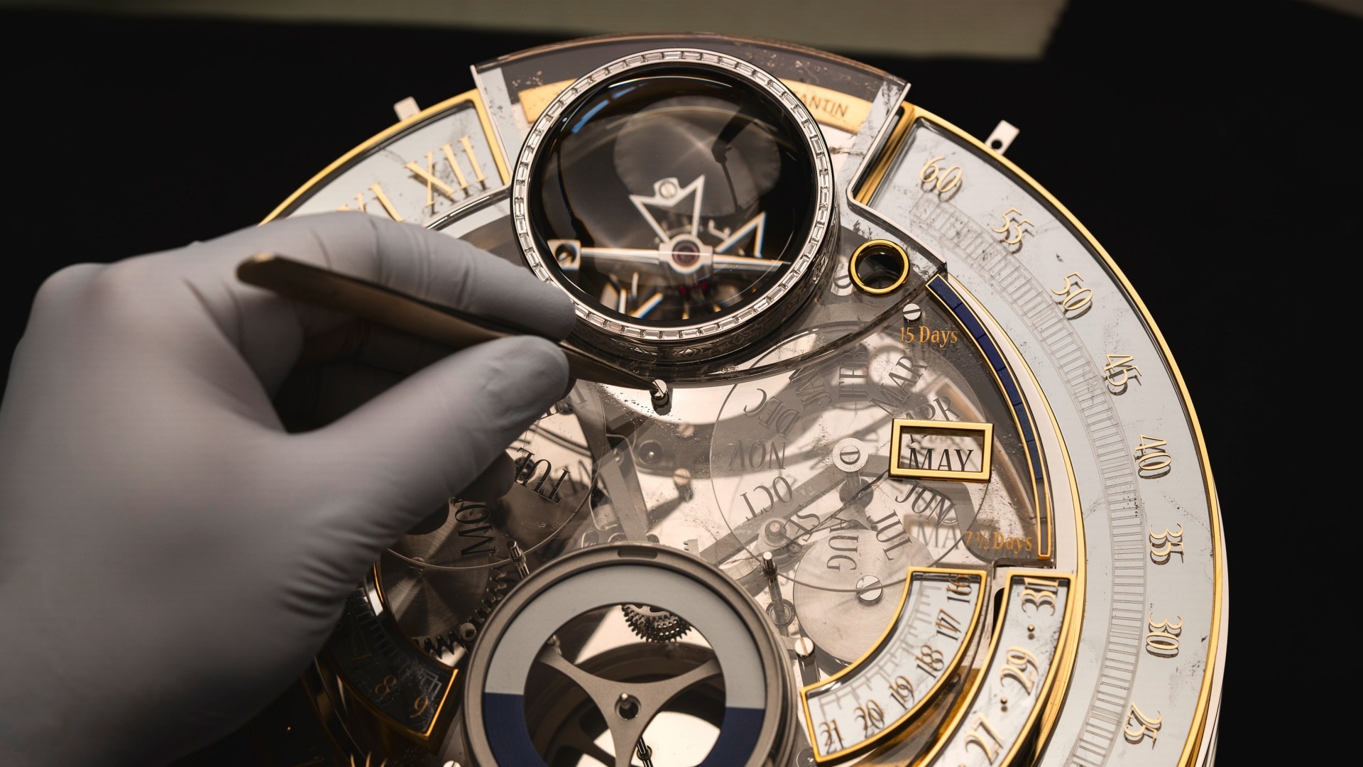 Image illustrating a gloved hand holding a pair of pliers on a dial