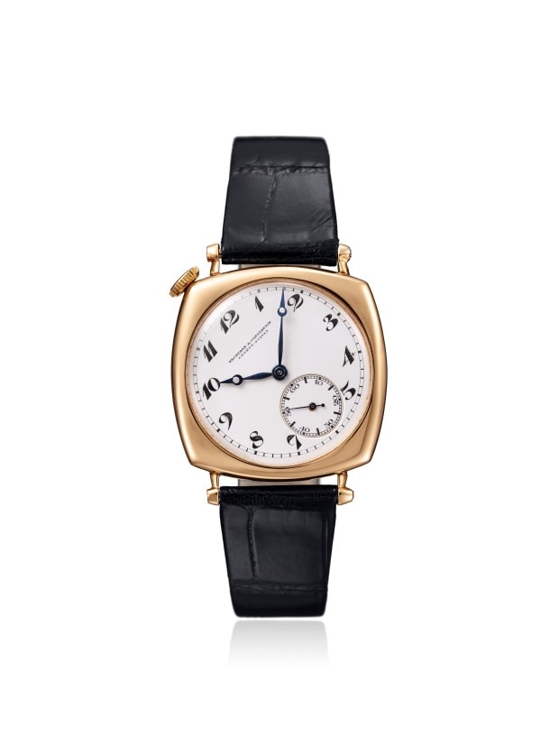 Gold cushion-shaped wirstwatch with a black leather strap and subdial.