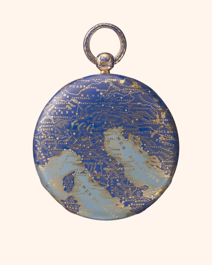 A pocket watch with a detailed map of Europe on its cover, featuring gold text on a blue background.