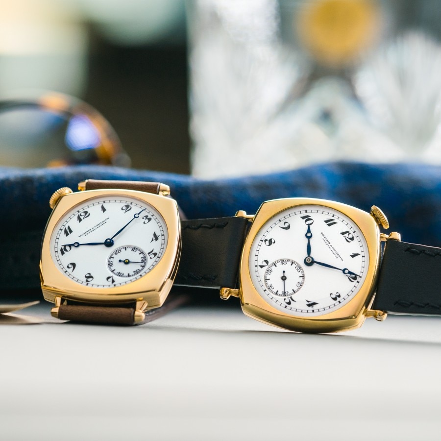 Two watches with gold, square frames and dark leather straps