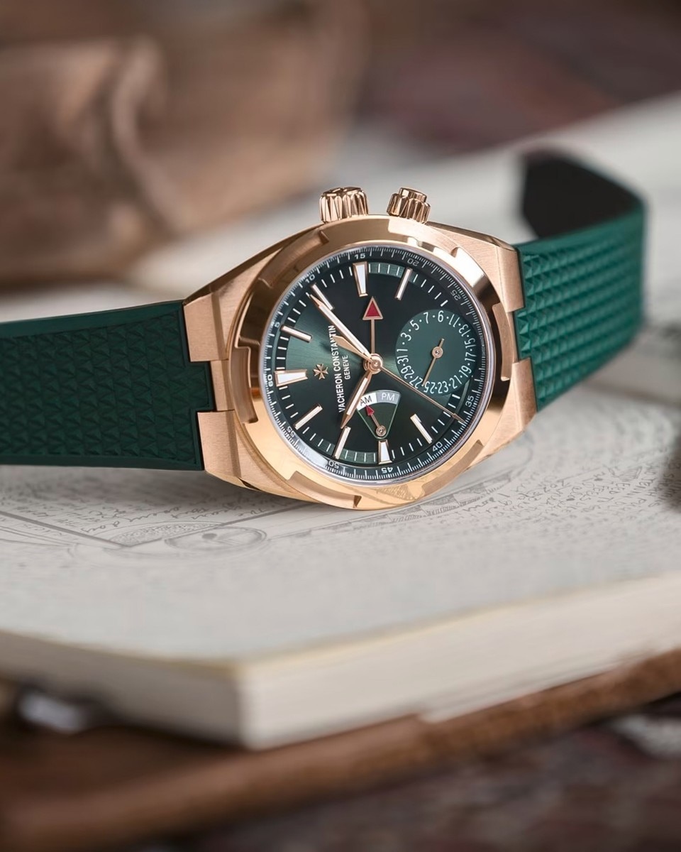 Cronografo Vacheron Constantin con cinturino e quadrante verdi, che poggia su un libro bianco chiuso.