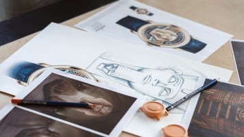 Artistic workspace with sketches, watch designs, and scattered drawing tools on a desk.
