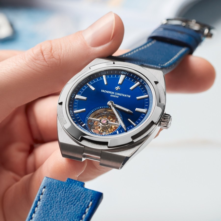 Person changing the strap of an Overseas Tourbillon in titanium with blue dial and blue strap