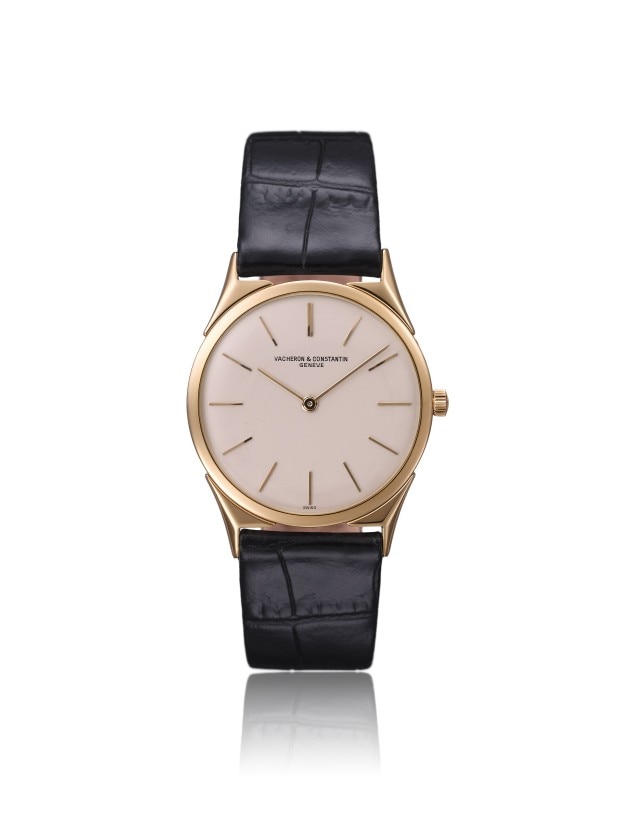 A slim gold wristwatch with a leather strap.