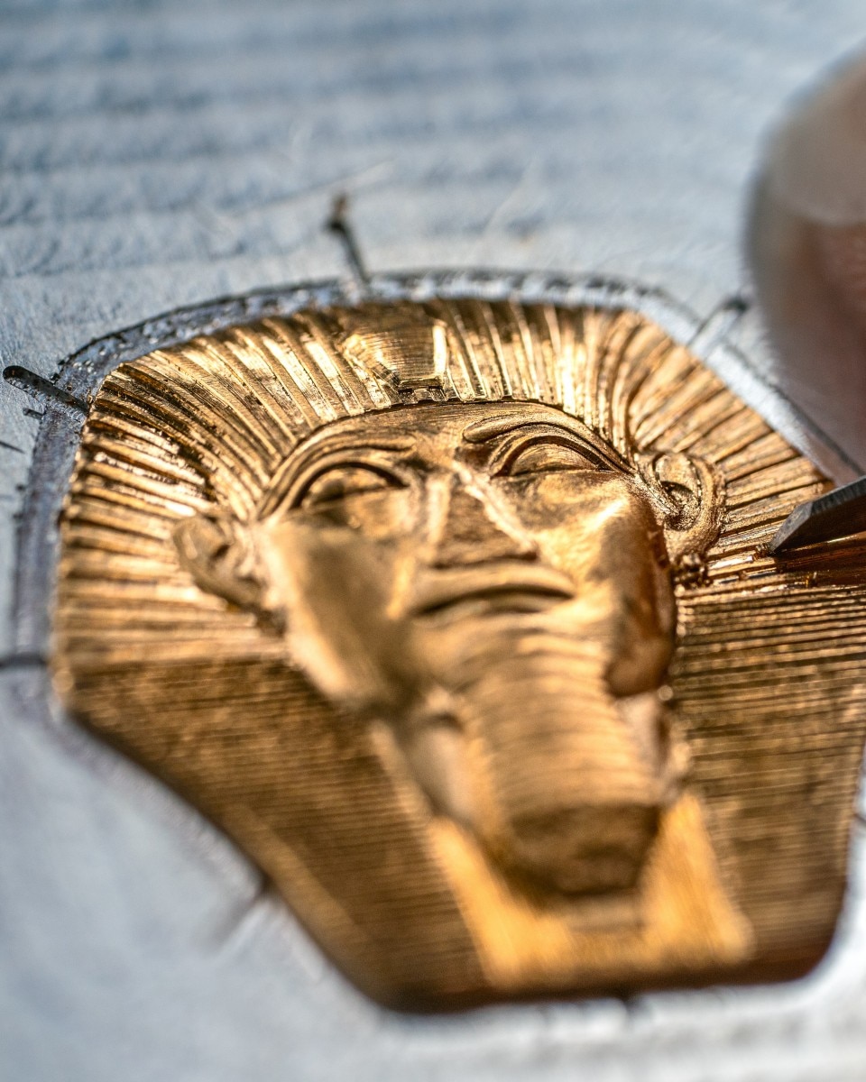 Macro view of a golden pharaoh engraving in progress.