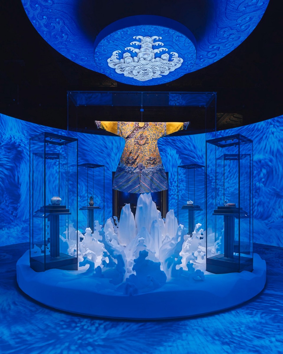 Blue-lit museum exhibition featuring crystal sculptures and digital art displays.