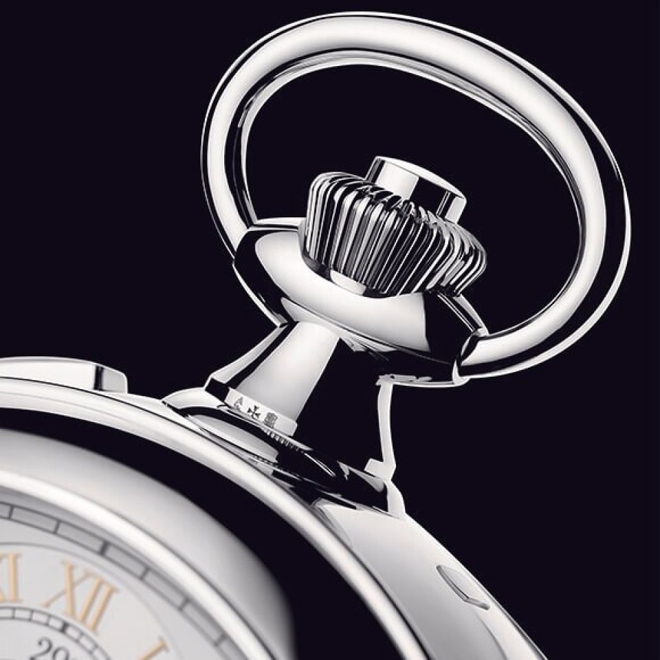 Close-up of the reference 57260 watch crown against a black background.