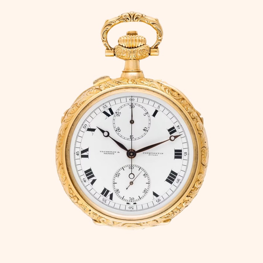 An ornate gold pocket watch with a white face, Roman numerals.