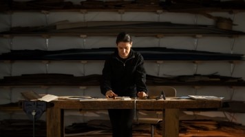 Artist crafting a handmade bird wood inlay piece.