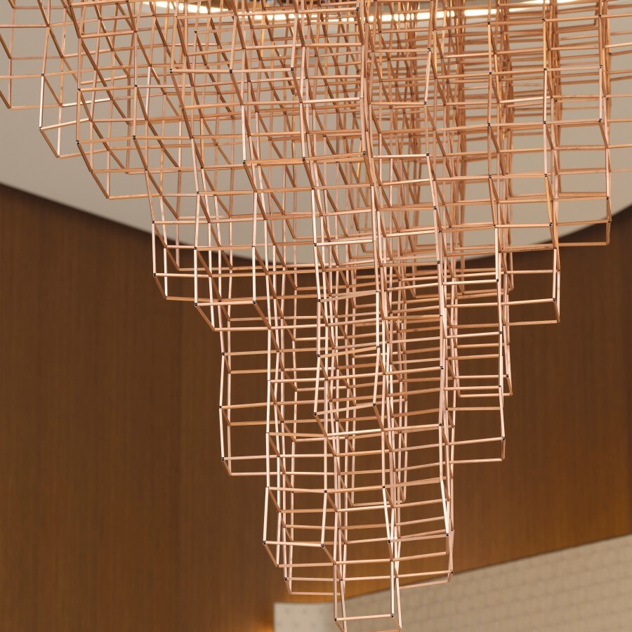 The chandelier, located in the central area of the boutique, is made of elegant rose gold tones, adding a luxurious feel to the space.