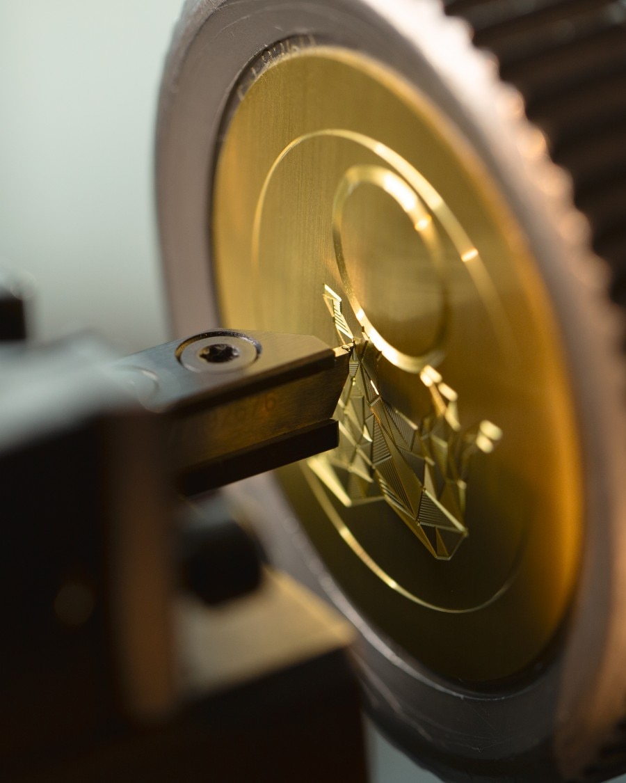 Guilloche engraving tool working on a golden watch plate.