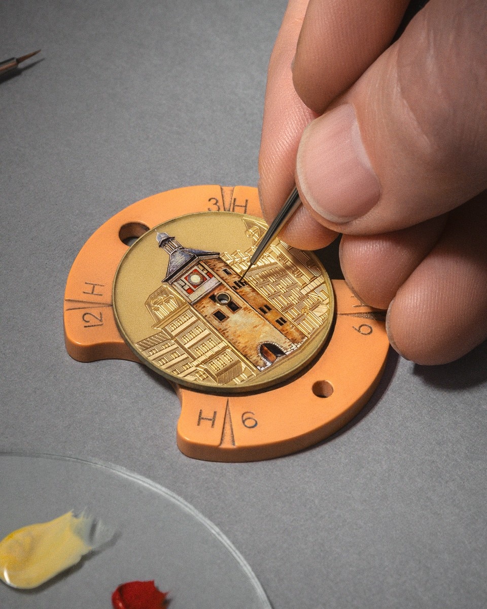 Pittura a mano di un edificio in miniatura su un quadrante di un orologio con dettagli raffinati