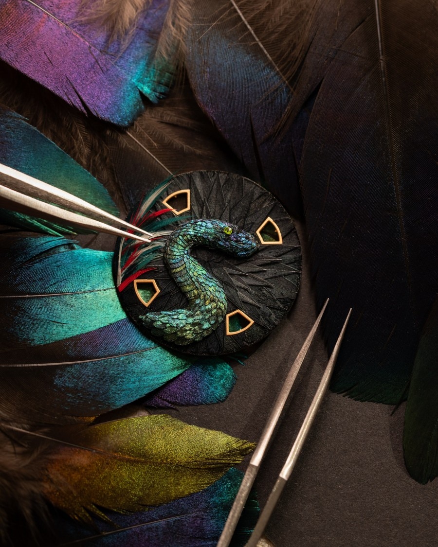 Feather snake design with colourful feathers in the background.