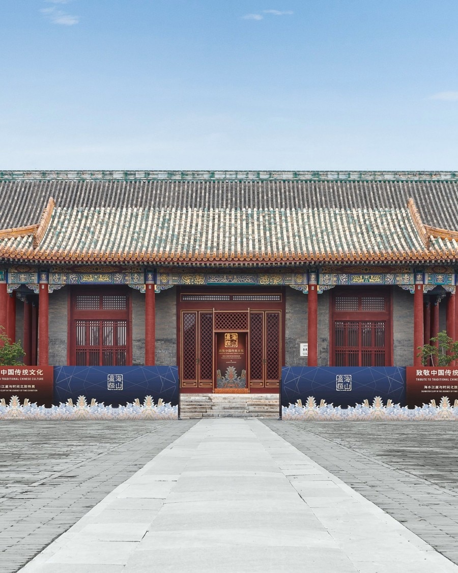 Traditional Chinese building with red columns and a stone path leading to the entrance.