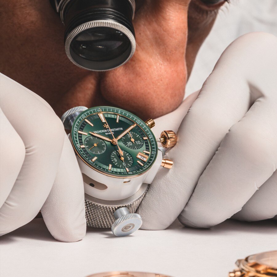 Watchmaker looking at a watch dial with a magnifying glass