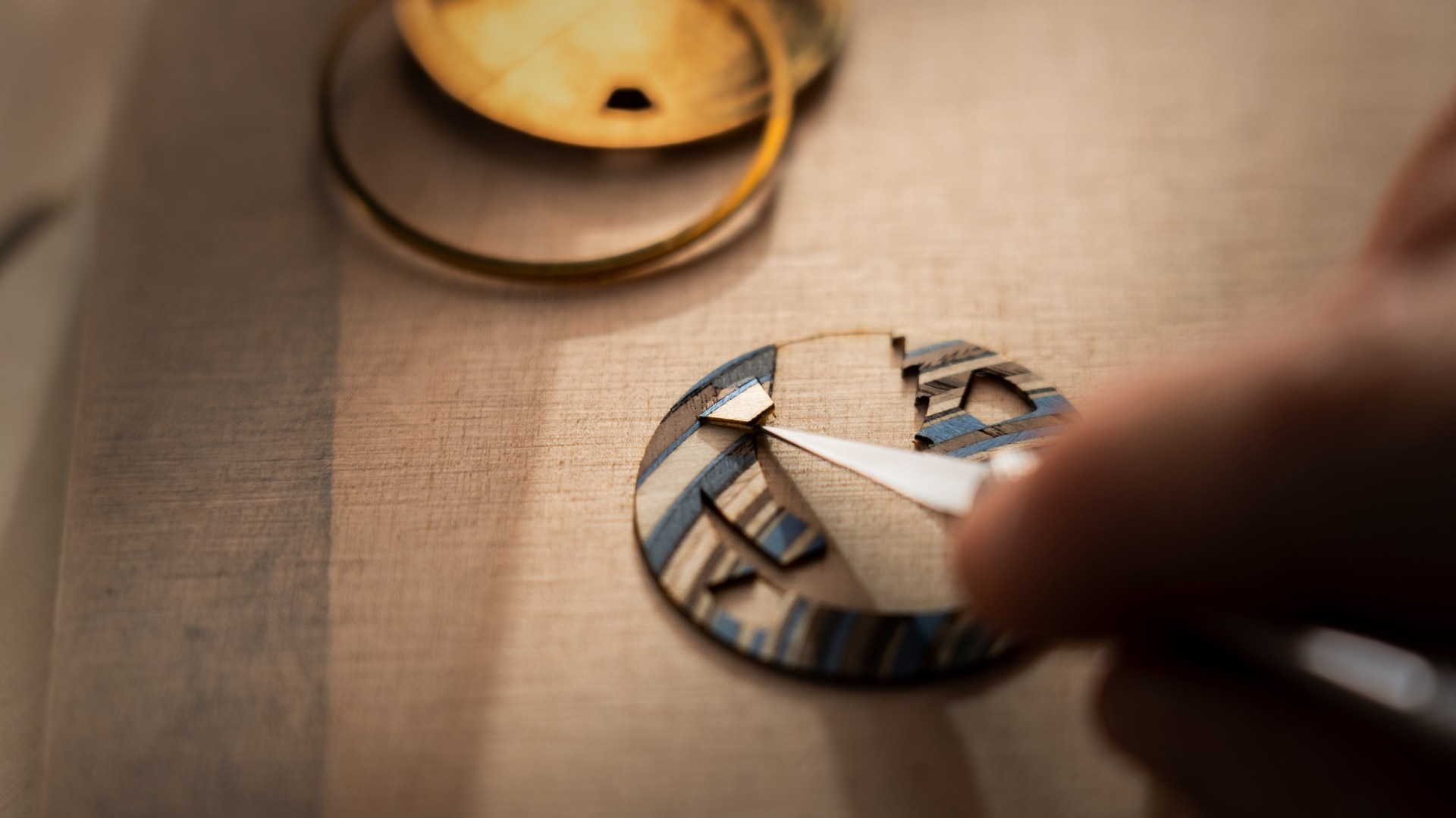 Artist using tweezers to place fine handcrafted details.