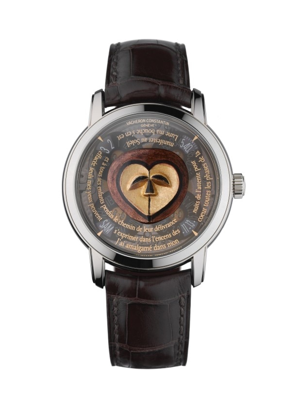 A silver wirstwatch with a black leather strap, featuring an artistic dial with a golden abstract face design and French text.