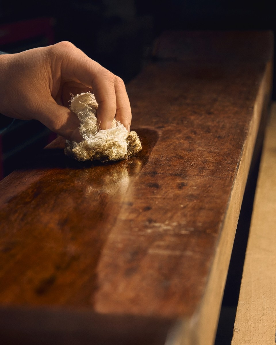 Hand polishing a wooden surface.