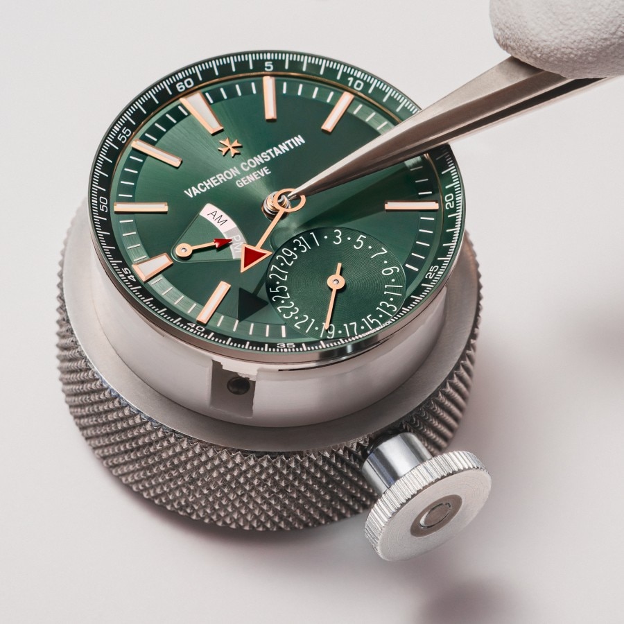 Watchmaker working on a watch an Overseas Dual time green dial