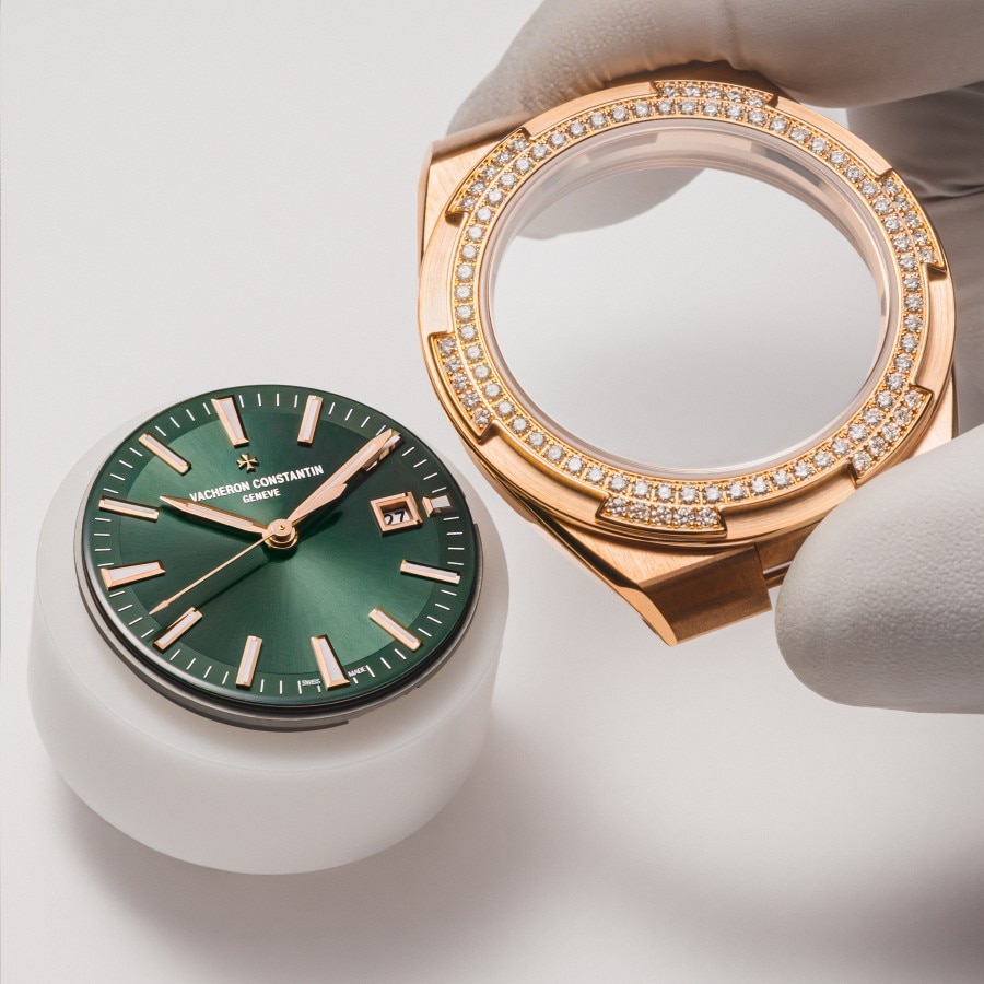 Watchmaker assembling an Overseas watch with a green dial and a bezel set with diamonds