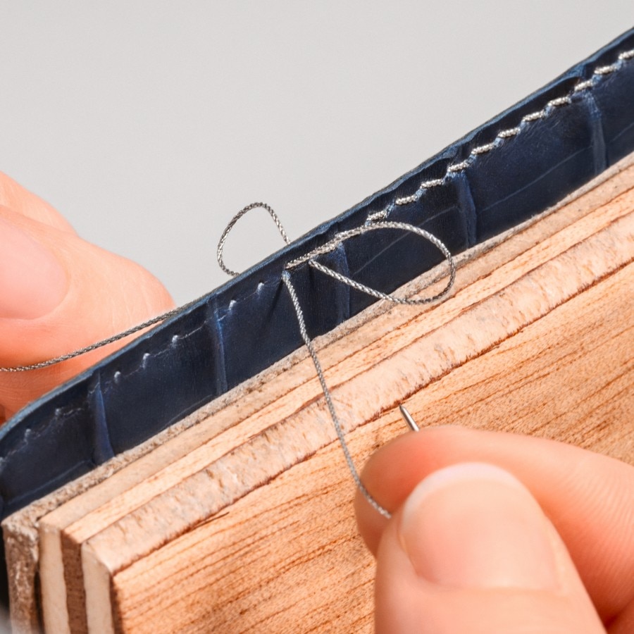 couturiere sewing a blue strap