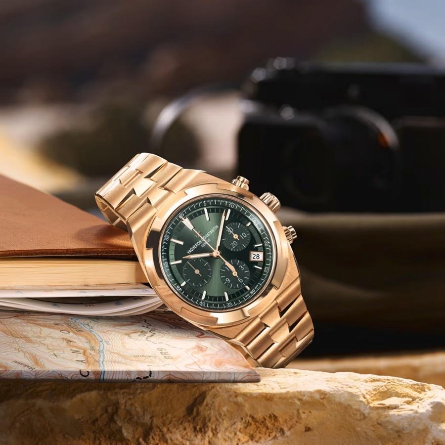 Vacheron Constantin cronografo in oro con quadrante verde, posizionato su una superficie strutturata.