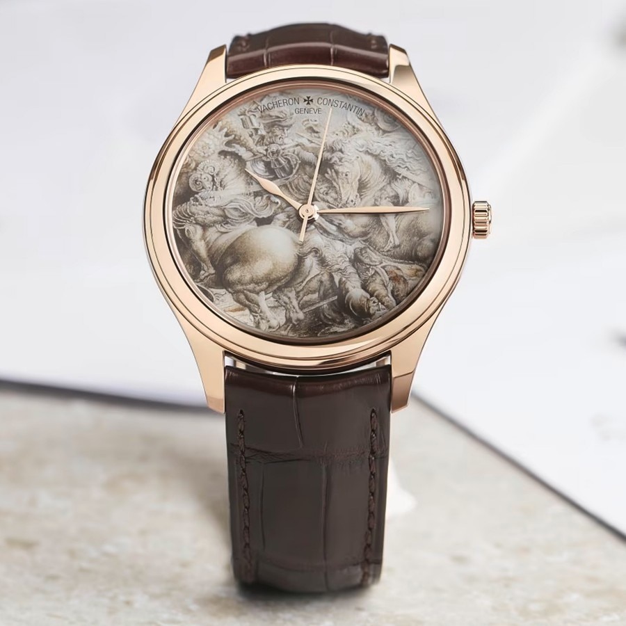 Elegant watch with a merbled grey dial, gold case, and dark leather strap dispalyed on a light surface.