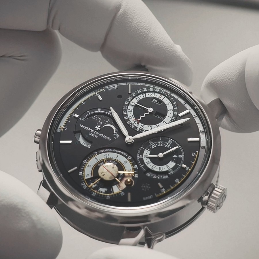 Mani che reggono la cassa di un orologio con lunetta nera e dettagli argentati