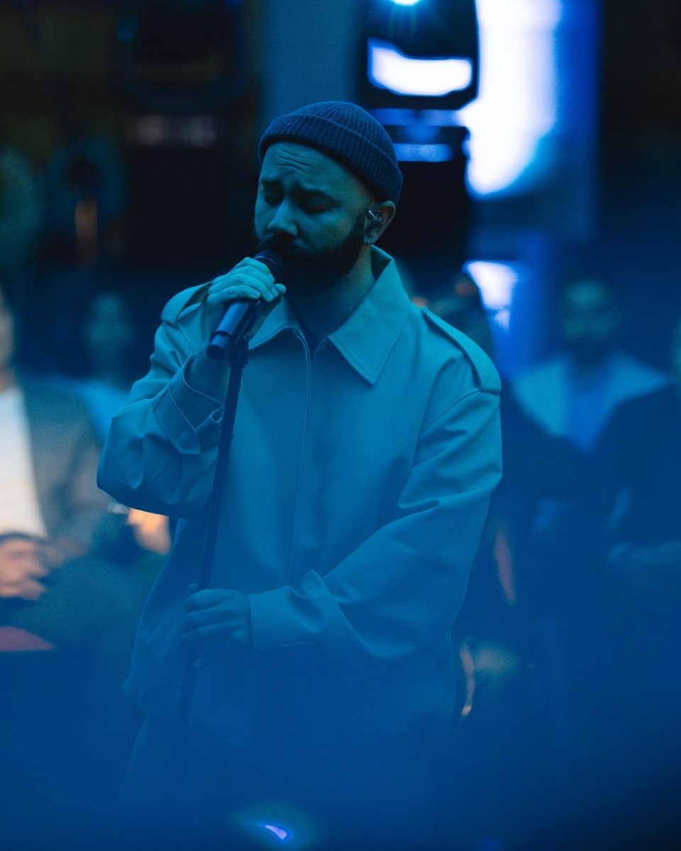 Woodkid singing on stage.