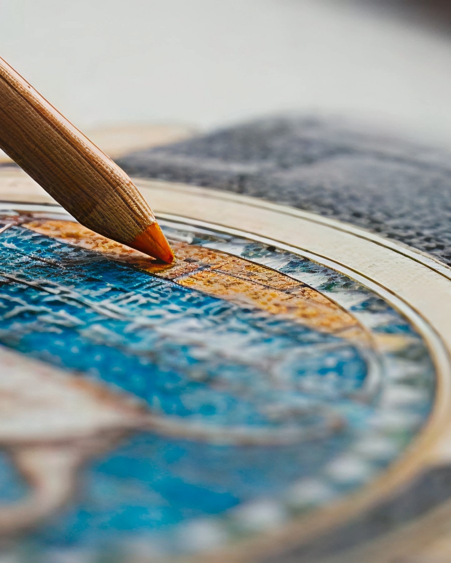 Artigianato, arte e cultura Detailed view of a hand painting blue and gold details on a watch dial using a fine brush.