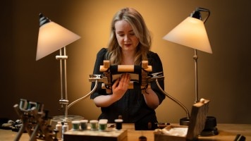 Artist creating a gold embroidery piece.