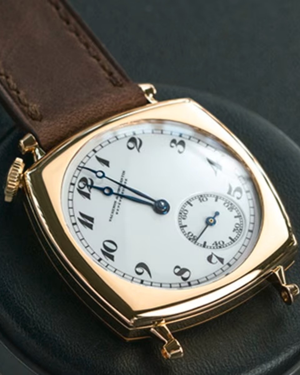 Close-up of a vintage Vacheron Constantin watch with a white dial and brown leather strap.