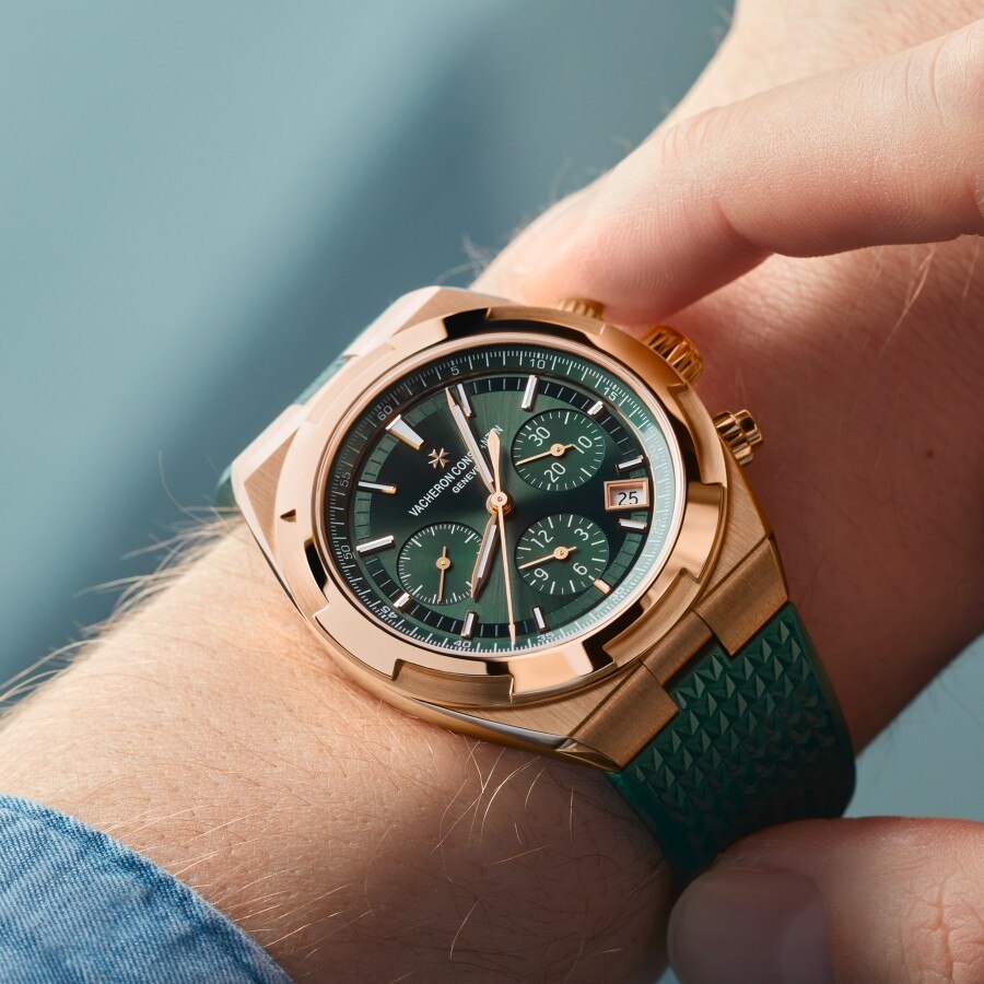 Person wearing an Overseas Chronograph in pink gold with a green dial and green rubber strap