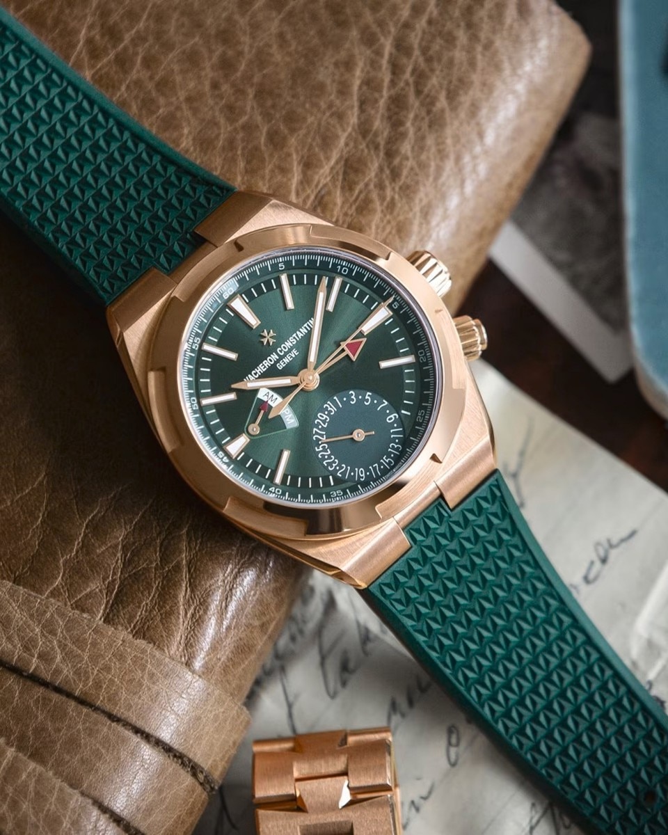 Cronografo Vacheron Constantin con quadrante verde e cinturino verde, poggiato su una superficie in pelle.