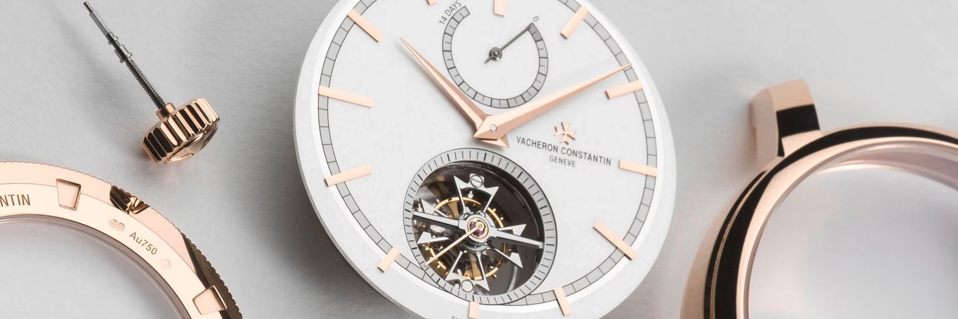 Close-up view of a watch case with light gray and gold elements and with a partially visible watch mechanism